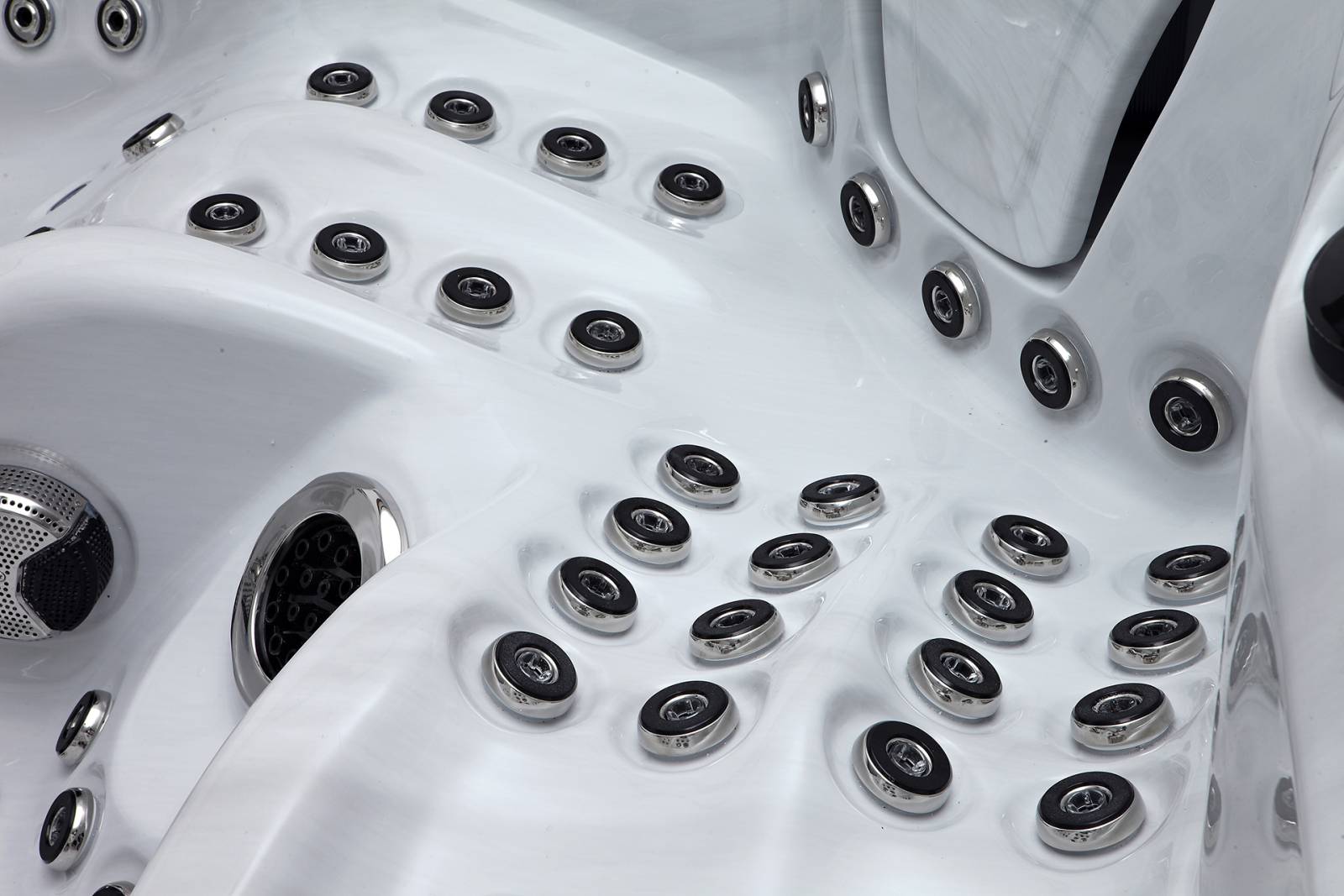 Intérieur moderne d'un bain à remous blanc avec de nombreux hydrojets circulaires et grilles de haut-parleurs en métal.