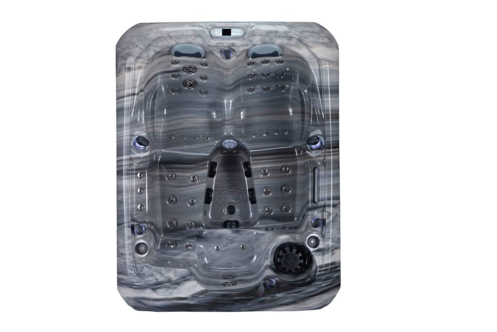 Vue de dessus d'un spa ou jacuzzi rectangulaire, intérieur effet marbre gris et noir, avec sièges moulés et multiples buses de massage chromées. Panneau de contrôle VENDOM visible.