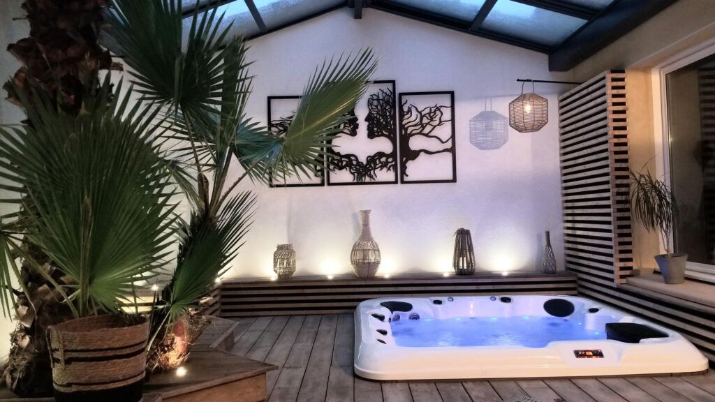 Spa Jacuzzi intérieur: l'espace détente tropical parfait. Luxueux jacuzzi intérieur/extérieur avec éclairage bleu, décoration tropicale, œuvre d'art murale et ambiance boisée.
